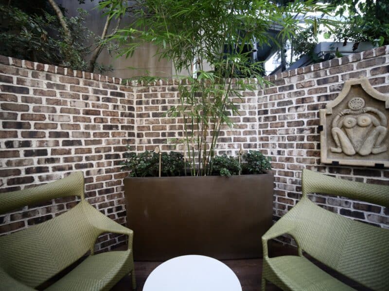 Brick-walled downtown courtyard in Savannah with a side path and lush plantings, installed by Victory Gardens.