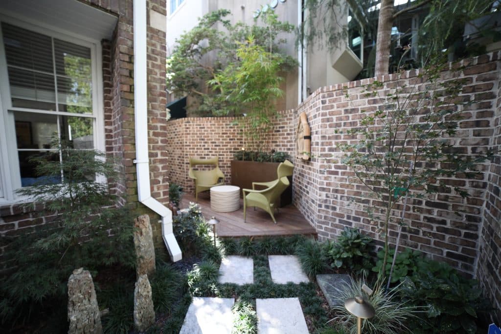 Wall fountain and soft landscape lighting in a compact Savannah courtyard installed by Victory Gardens.